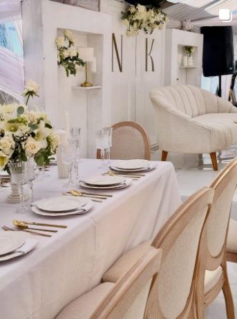 White styled celebration table with monogram backdrop